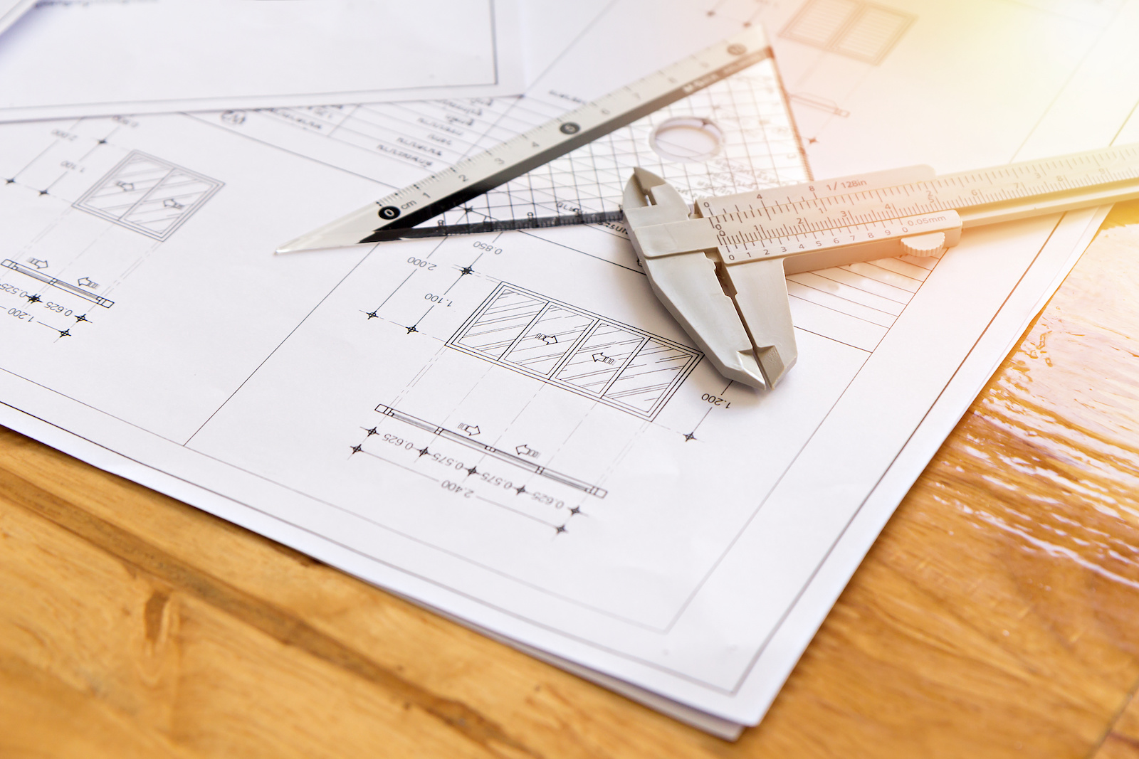 Close up of caliper with architect sketching a construction project